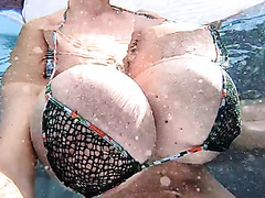 Busty Milf playing with her huge boobs in an outside pool